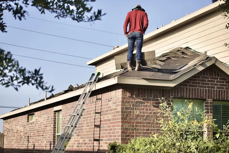 Professional roofer working on a residential roof in New Village